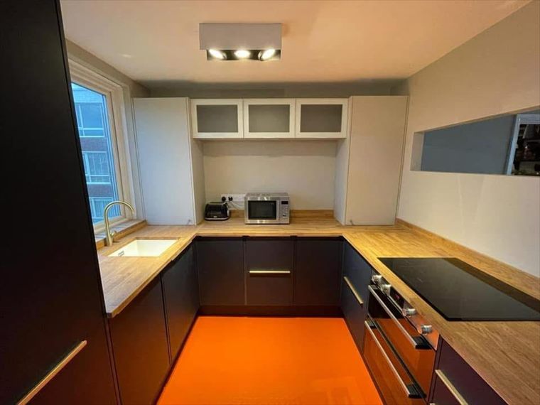 Navy handleless kitchen with oak worktops